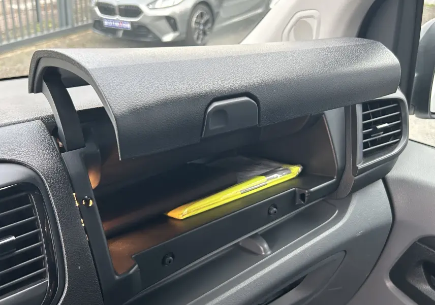 Détail intérieur montrant le bouton de désactivation de l'airbag passager sur la portière d'un Citroën Jumpy blanc.