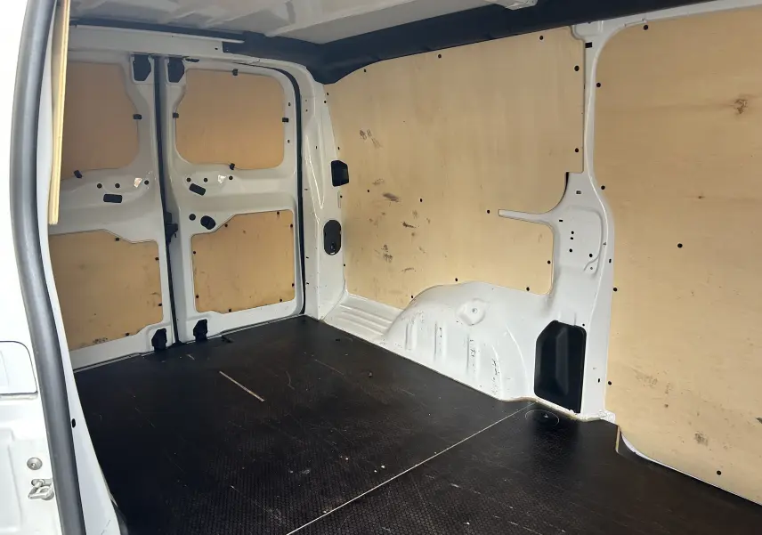Intérieur du fourgon blanc Citroën Jumpy XL 2019, vue de l'espace de chargement avec habillage bois et sol noir antidérapant.
