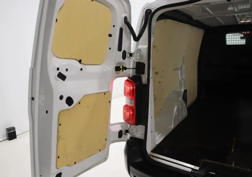 Vue arrière ouverte du Citroën Jumpy blanc, montrant l'intérieur fourgon avec habillage bois sur portes et parois.