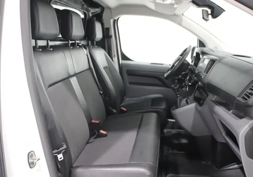 Intérieur du Citroën Jumpy Fourgon XL 2019, vue côté conducteur montrant sièges noirs et tableau de bord fonctionnel.
