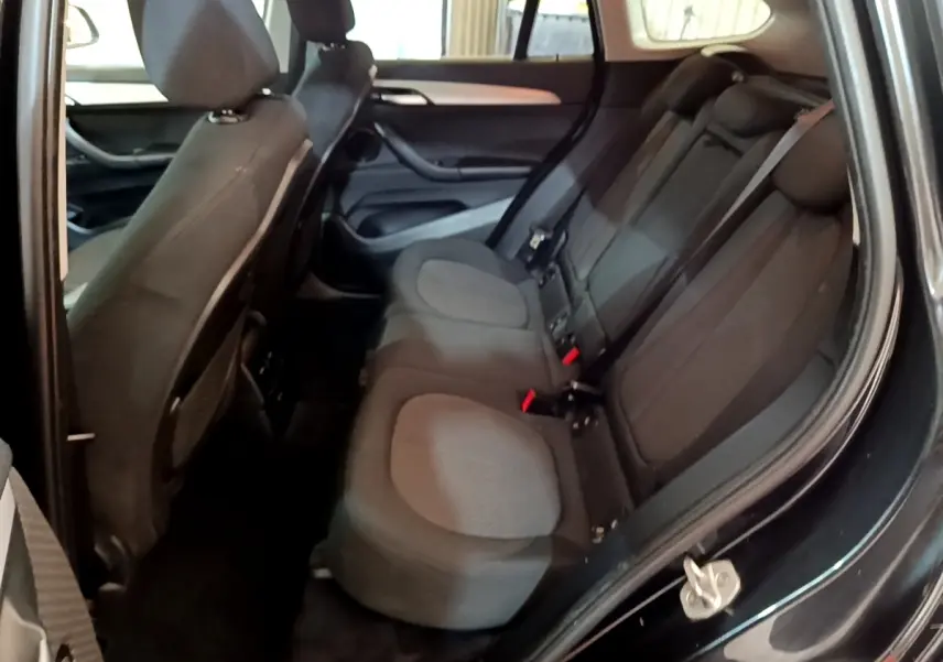 Vue intérieure côté droit montrant la banquette arrière noire du BMW X1 sDrive16d Business Design 2020.
