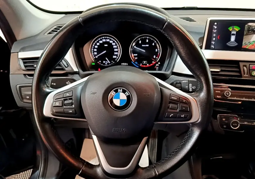 Vue rapprochée du volant cuir noir de la BMW X1 2020 avec tableau de bord et écran tactile multifonctions.