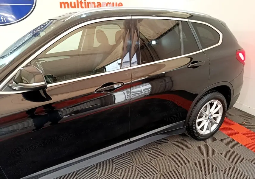 Vue latérale côté gauche d'un BMW X1 noir 2020 avec jantes alliage et rétroviseur chromé électrique.