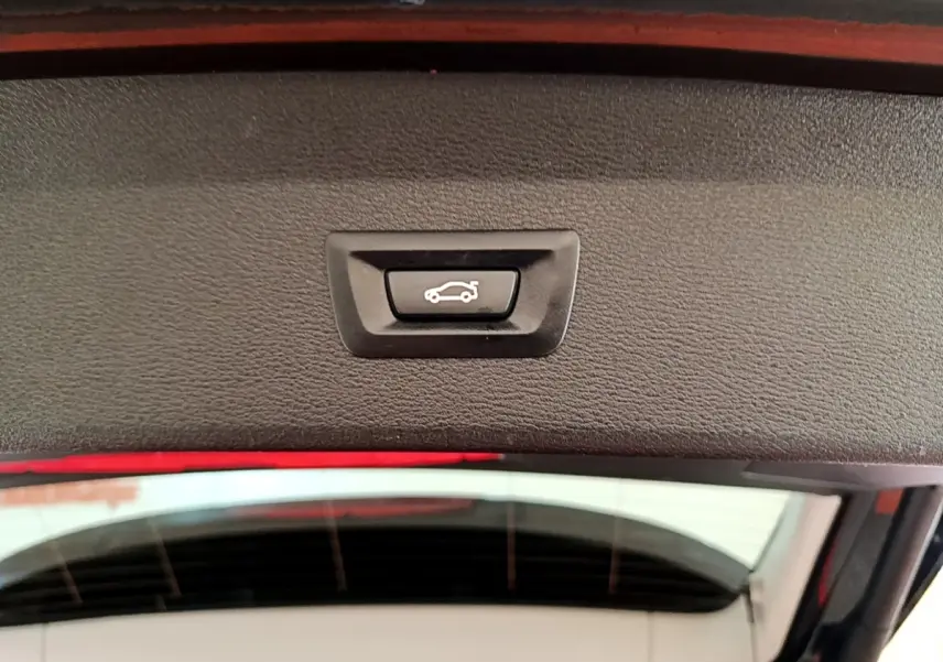 Bouton de fermeture électrique du coffre vu de l'intérieur du hayon d'un BMW X1 noir 2020 sDrive16d Business Design DKG7.