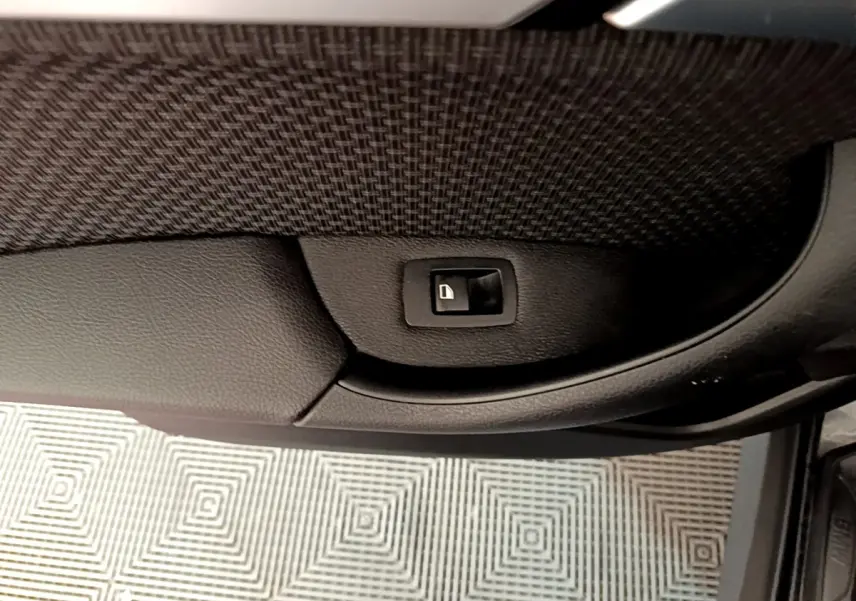 Bouton de verrouillage de porte intégré dans la garniture intérieure noire de la portière côté conducteur du BMW X1 noir 2020.