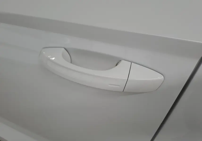 Poignée de porte blanche lune du Skoda Karoq 2025 vue en gros plan sur la portière côté droit.