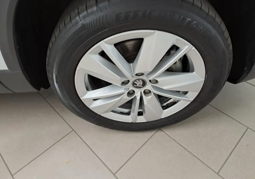 Gros plan sur la roue avant gauche du Skoda Karoq blanc lune 2025 avec jante alliage à cinq doubles branches.