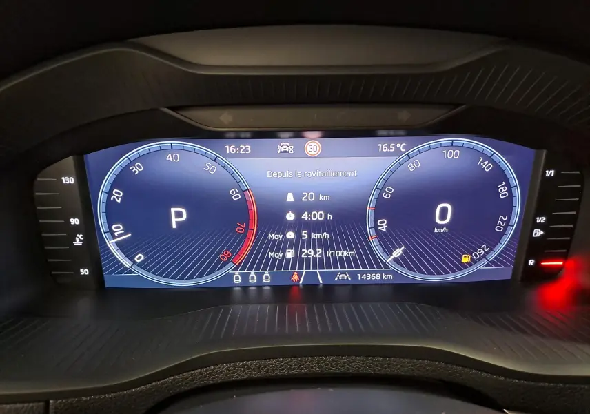 Vue rapprochée du tableau de bord numérique du Skoda Karoq 2025, affichant la vitesse, la température et l'autonomie.
