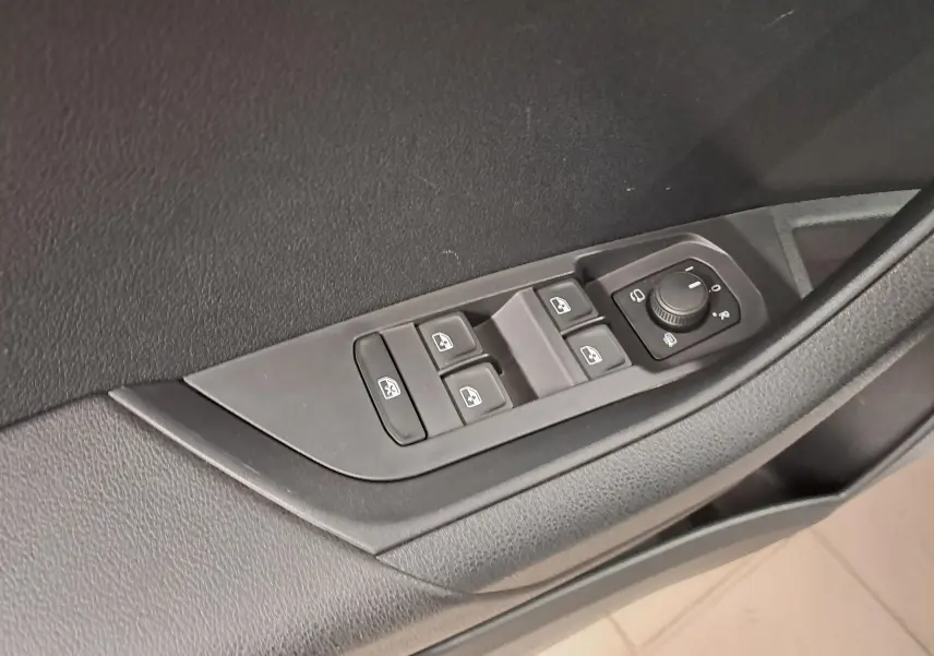 Commande des vitres et réglage des rétroviseurs sur la porte côté gauche d’un Skoda Karoq 2025 noir.