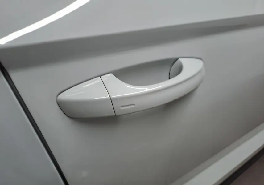 Poignée de porte blanche lune en gros plan sur la portière d'un Skoda Karoq 2025, version 1.5 TSI 150 DSG7 Selection.