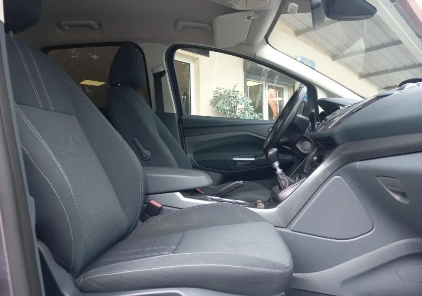 Vue intérieure côté droit du Ford C-MAX gris 2015, montrant les sièges avant et la console avec levier de vitesses manuel.