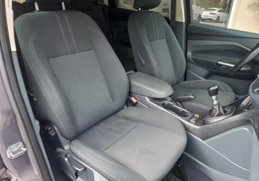 Vue intérieure côté gauche du Ford C-MAX gris 2015, montrant les sièges avant et la boîte manuelle.
