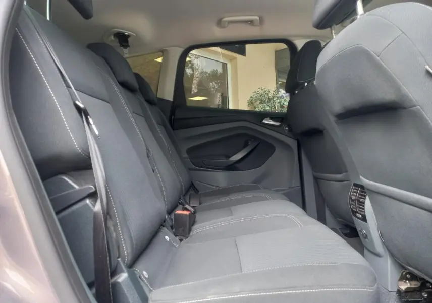 Vue intérieure côté gauche des sièges arrière gris du Ford C-MAX 2015, version Titanium X avec ceintures visibles.