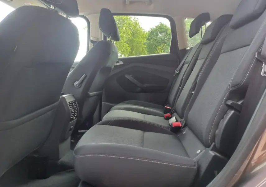 Vue intérieure côté droit des sièges arrière noirs du Ford C-MAX gris 2015 version Titanium X, avec ceintures visibles.
