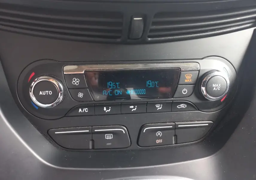 Vue rapprochée de la console de climatisation du Ford C-MAX gris 2015 avec affichage digital et commandes circulaires.