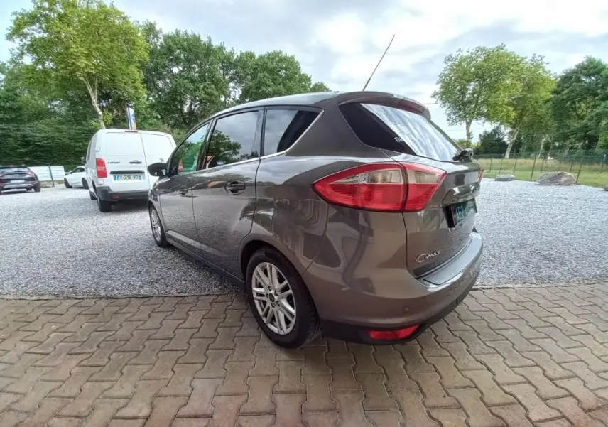 Vue 3/4 arrière droite d'une Ford C-MAX gris métallisé 2015 avec jantes alliage et vitres teintées.