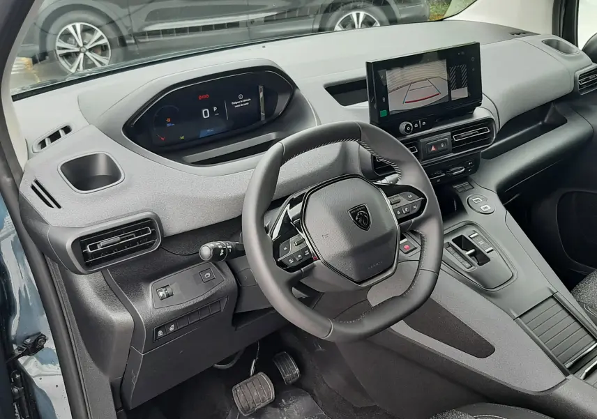 Vue intérieure côté conducteur du Peugeot Rifter bleu Kiama 2026, avec tableau de bord digital et écran tactile central.