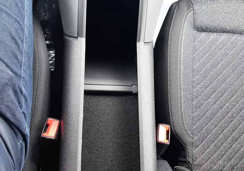 Vue plongeante sur la console centrale noire et les sièges tissu gris du Peugeot Rifter Bleu Kiama, version 2026.