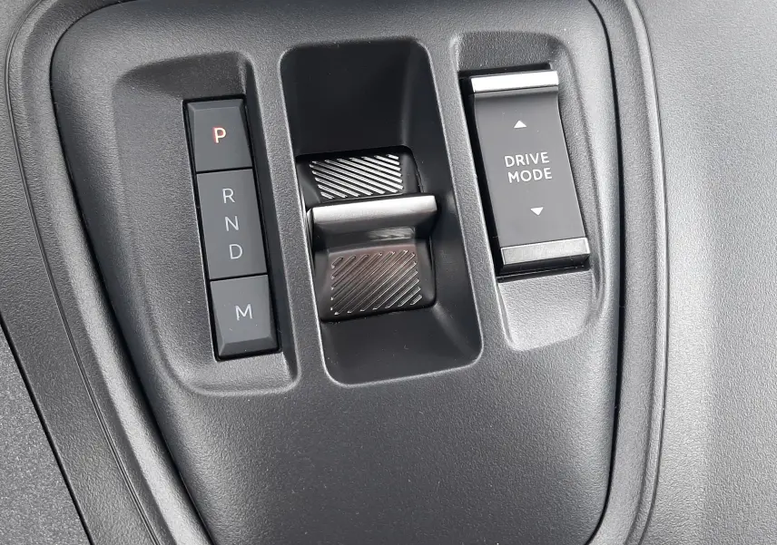 Gros plan sur la commande de boîte automatique et le sélecteur Drive Mode du Peugeot Rifter III Ph.2 intérieur noir.