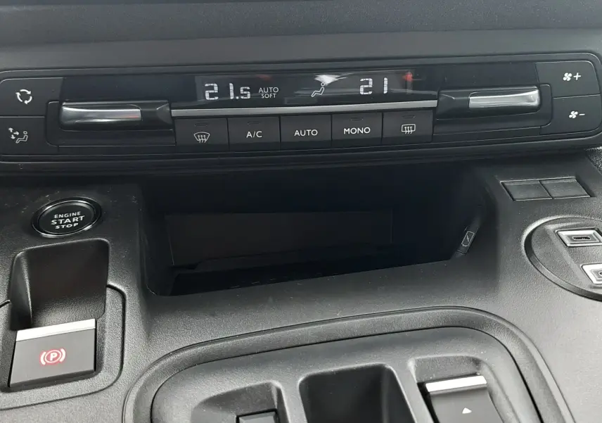 Gros plan sur la console centrale du Peugeot Rifter bleu Kiama 2026, montrant la climatisation automatique et les commandes de boîte auto.