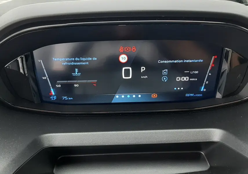 Tableau de bord numérique du Peugeot Rifter III gris acier, affichant la température liquide refroidissement et consommation instantanée.