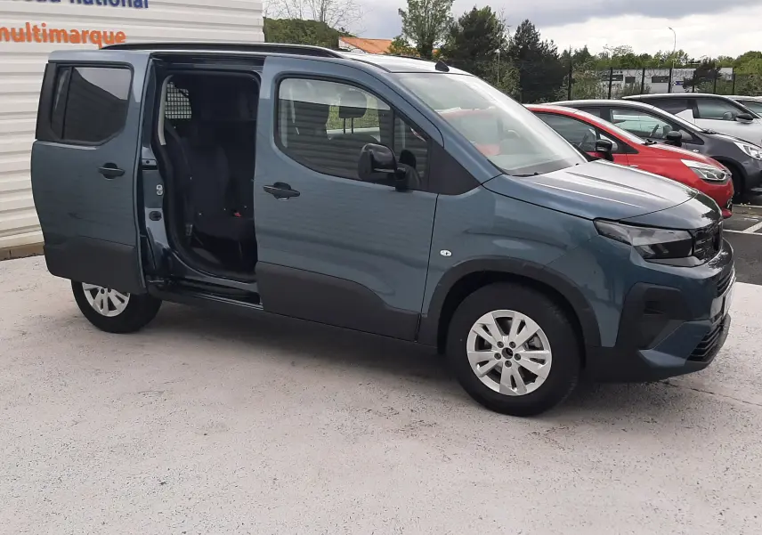 Peugeot Rifter bleu Kiama en 3/4 avant droit, porte latérale gauche coulissante ouverte, jantes alu 16 pouces visibles.
