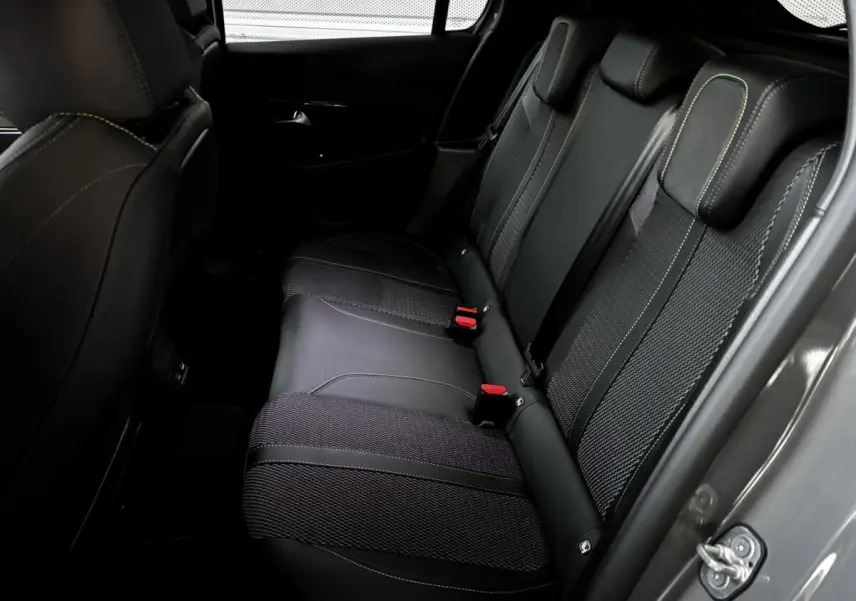 Vue côté droit de la banquette arrière en cuir noir avec surpiqûres vertes de la Peugeot 208 Hybrid 136 eDCS6 GT gris foncé.