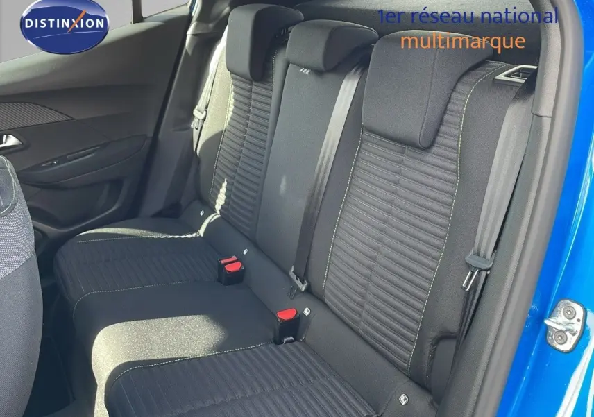 Vue intérieure sur la banquette arrière noire avec surpiqûres vertes d'une Peugeot 2008 bleu Vertigo 2024, porte ouverte côté droit.