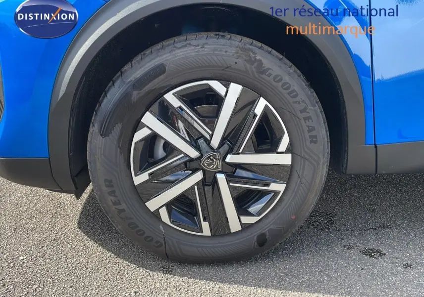 Gros plan sur la roue avant gauche d’un Peugeot 2008 bleu Vertigo Metal avec jante alliage noire et argentée.