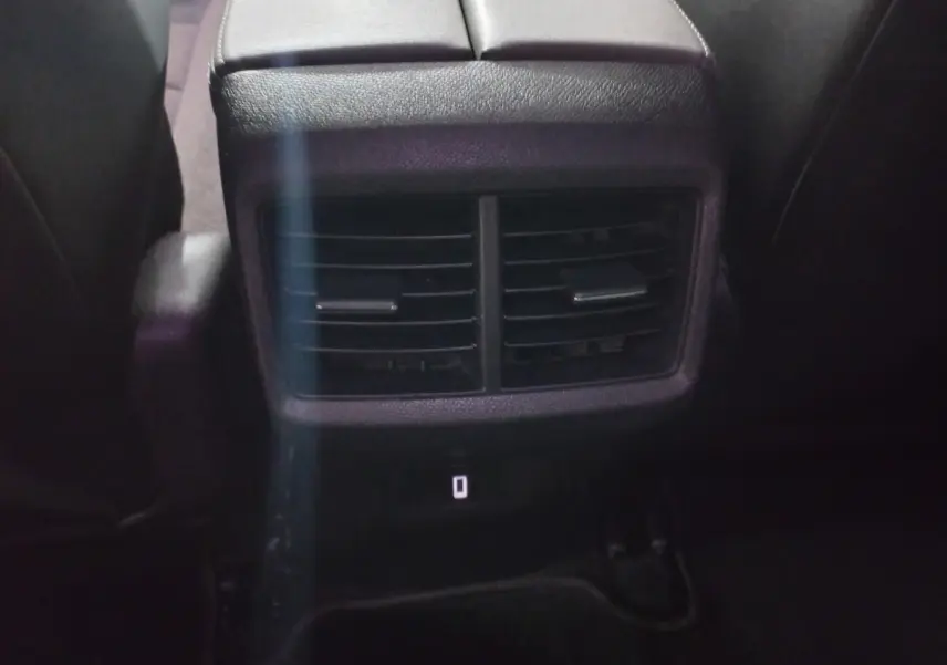 Bouche d'aération arrière noire vue de près entre les sièges arrière du Citroën C5 Aircross blanc 2020.