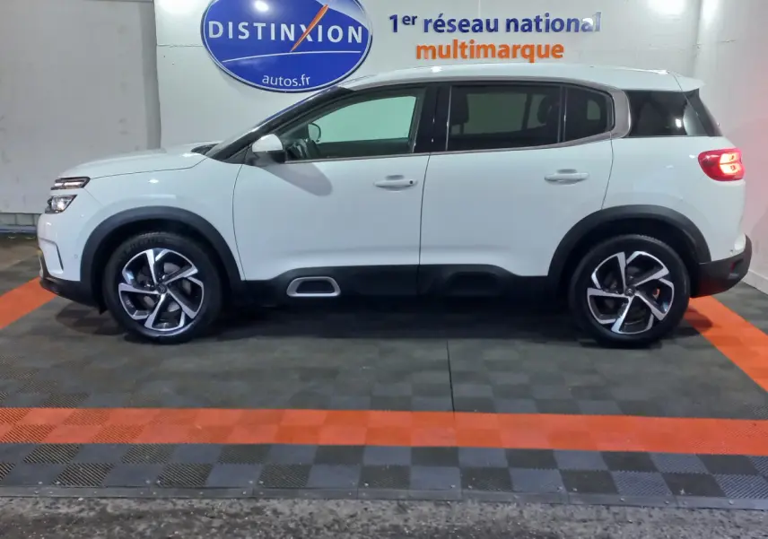 Profil droit d'un Citroën C5 Aircross blanc 2020 avec jantes alliage et protections noires sur bas de caisse.