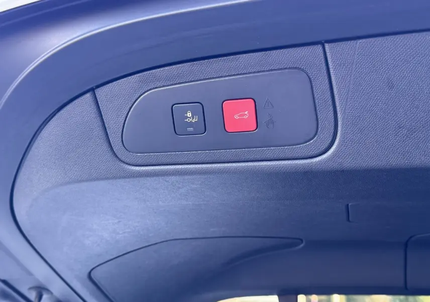 Gros plan sur le panneau de commandes du hayon électrique à l'intérieur du coffre d'un DS7 Crossback blanc.