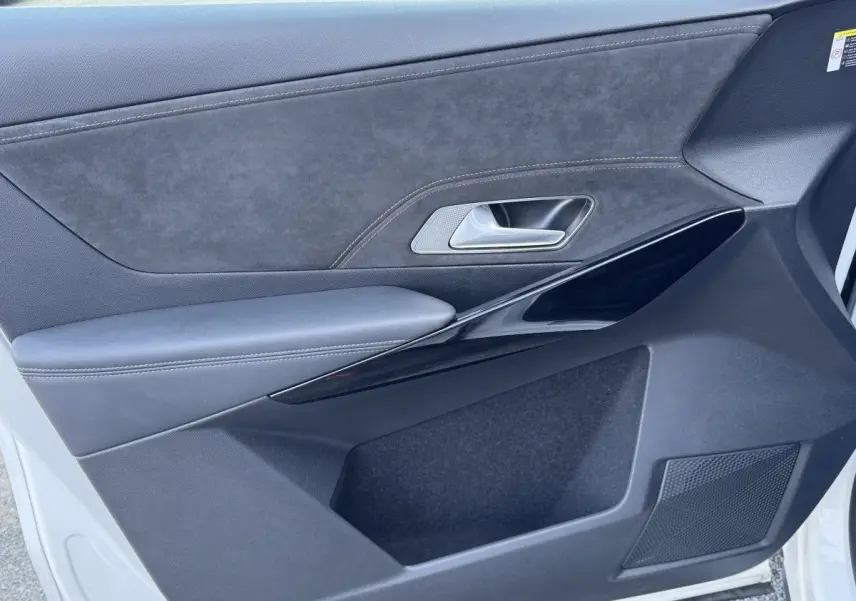 Vue rapprochée de la porte avant droite blanche du DS7 Crossback avec garniture noire et insert en alcantara.