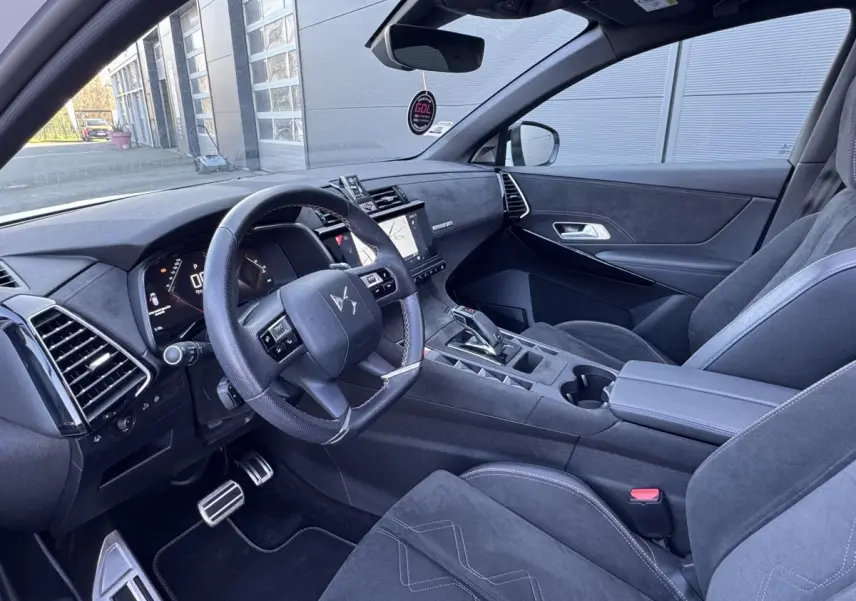 Vue intérieure côté conducteur du DS7 Crossback blanc 2020, mettant en valeur le volant cuir et l'écran tactile central.
