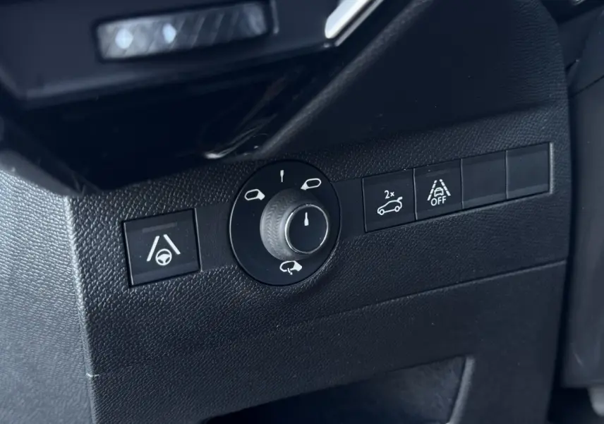 Gros plan sur les commandes de réglage des rétroviseurs et d'assistance à la conduite dans un DS7 Crossback blanc.