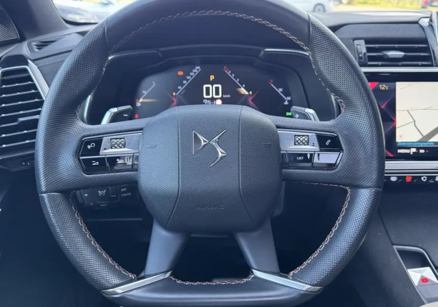 Vue rapprochée du volant cuir DS avec commandes intégrées et tableau de bord numérique du DS7 Crossback 2020.