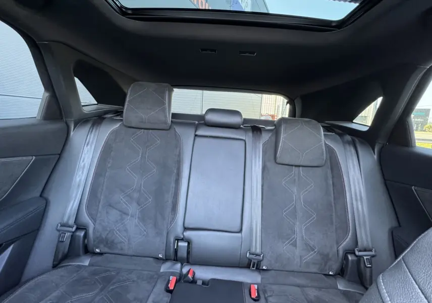 Vue intérieure arrière du DS7 Crossback 2020 montrant la banquette en cuir noir avec surpiqûres et toit ouvrant panoramique.