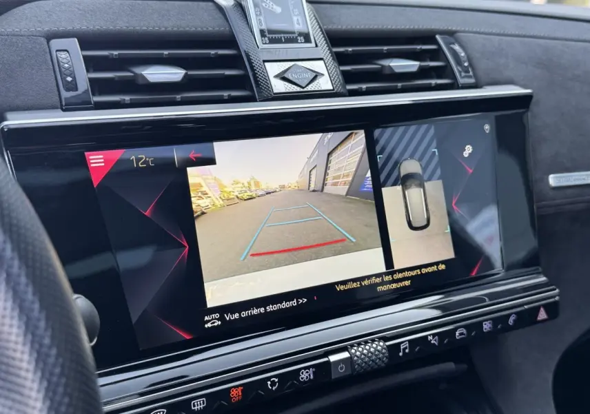 Vue rapprochée de l’écran tactile central du DS7 Crossback blanc 2020, affichant la caméra de recul et l’aide au stationnement.