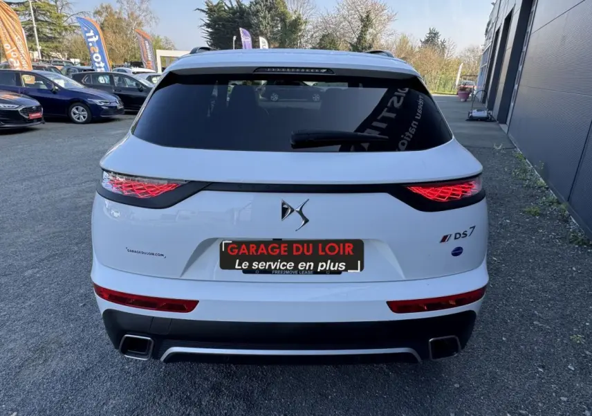 Vue arrière d'un DS7 Crossback blanc avec feux LED caractéristiques et double sortie d'échappement rectangulaire.