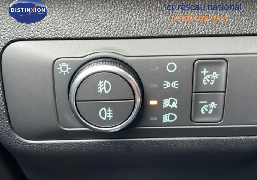 Gros plan sur le tableau de bord du Ford Kuga 2024, montrant la molette de réglage des phares et les commandes d’éclairage.
