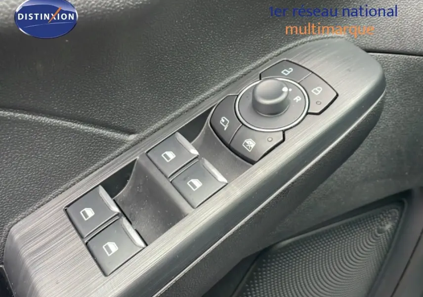 Gros plan sur les commandes des vitres et rétroviseurs côté conducteur du Ford Kuga 2024 bleu chrome.