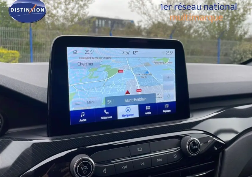 Vue rapprochée de l’écran tactile central du Ford Kuga 2024 bleu chrome, affichant la navigation GPS sur fond de tableau de bord noir.