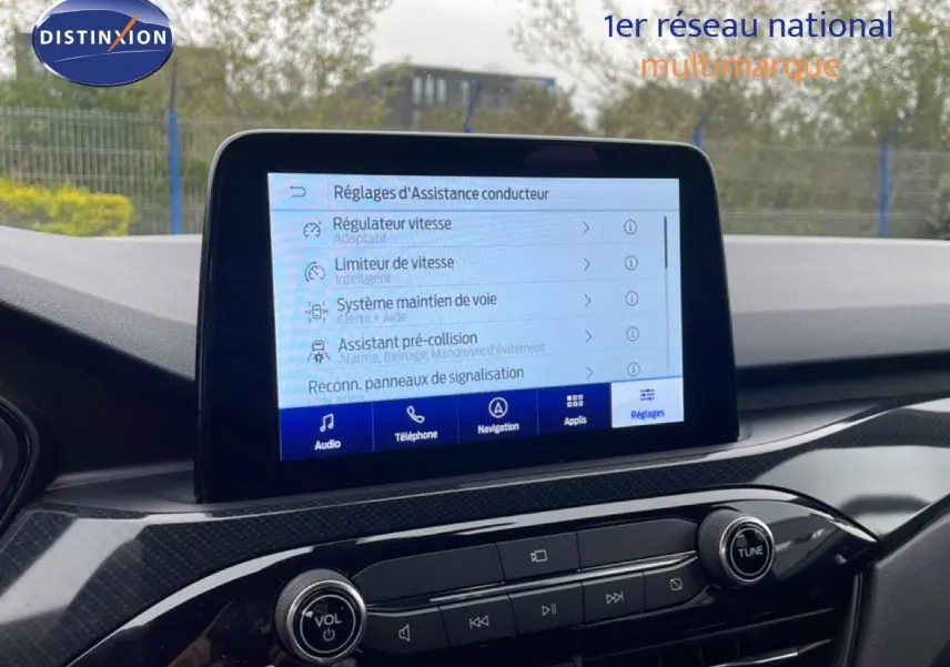 Vue intérieure du tableau de bord du Ford Kuga 2024 avec écran tactile affichant les réglages d'assistance conducteur.