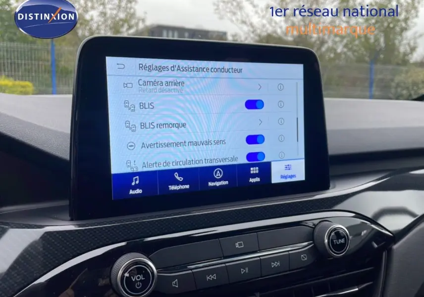 Vue rapprochée de l’écran central du Ford Kuga bleu chrome 2024 montrant les réglages d’assistance conducteur.