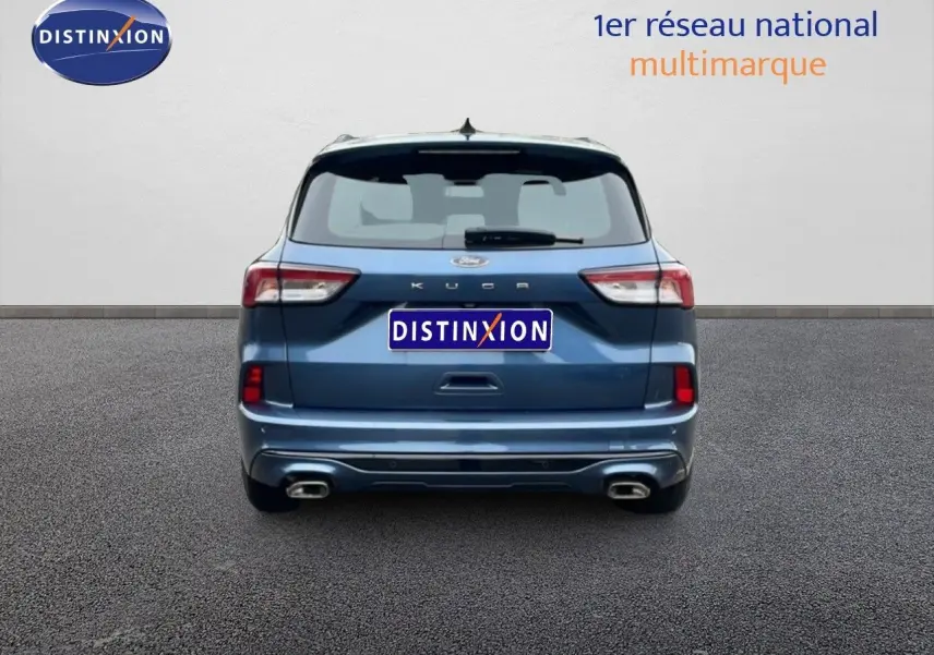 Vue arrière d'un Ford Kuga 2024 bleu chrome métal avec double sortie d'échappement et logo ST-Line visible.