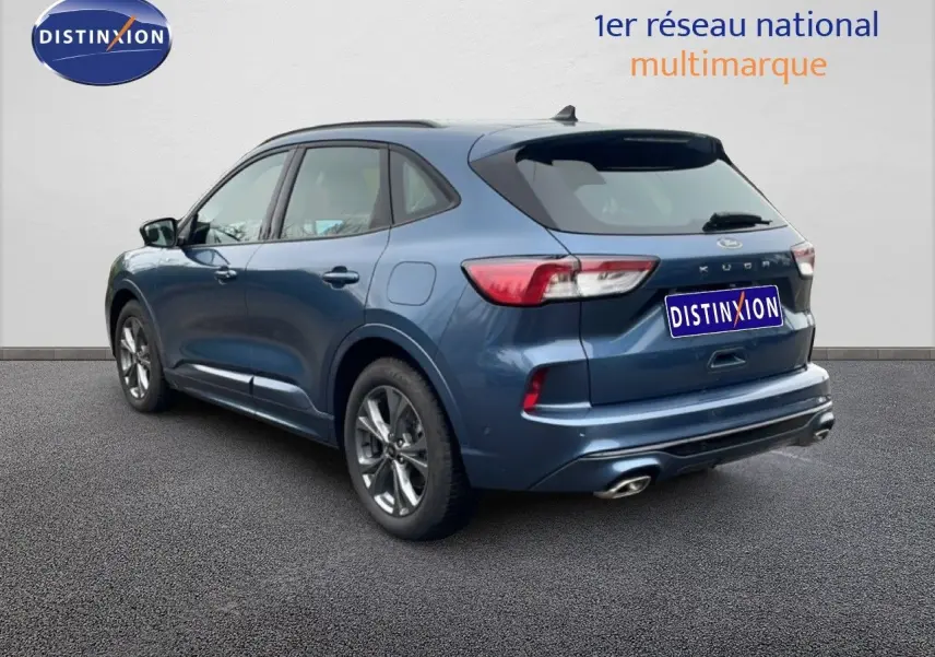 Vue 3/4 arrière droite d’un Ford Kuga bleu chrome métal 2024 avec double sortie d’échappement et jantes alliage.