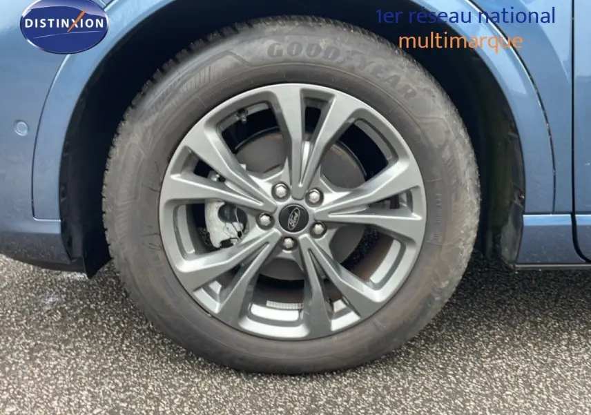 Gros plan sur la roue avant droite du Ford Kuga bleu chrome métal, mettant en valeur la jante alliage et le pneu Goodyear.