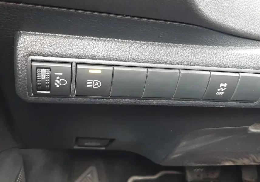 Gros plan sur les commandes noires du tableau de bord côté conducteur de la Toyota Corolla blanche 2022 hybride.