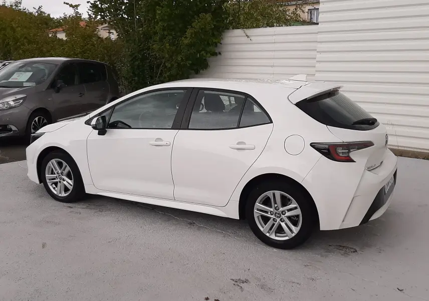 Toyota Corolla 122 CH Dynamic blanche vue de profil côté gauche, avec jantes alliage et vitres teintées arrière.