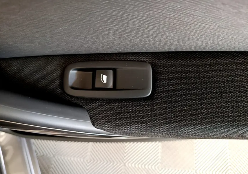 Bouton de commande de lève-vitre sur la porte intérieure d'une Citroën Grand C4 Spacetourer gris foncé.